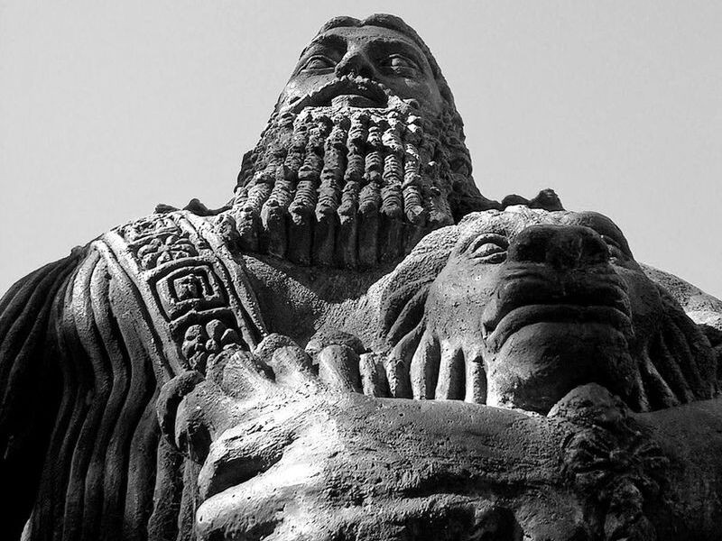 Close up image of a stone statue of Gilgamesh. We look at at it, looming large in the frame.